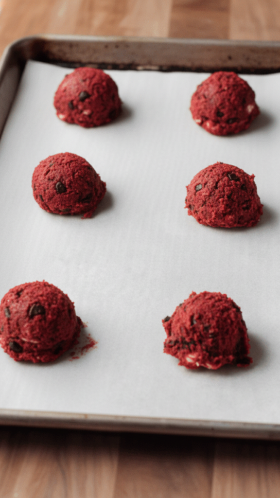 Red Velvet Oreo Cookie mixture rolled up and put onto a baking tray